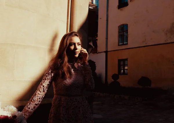 Lovely brunette model posing at the courtyard with shadow on her — ストック写真