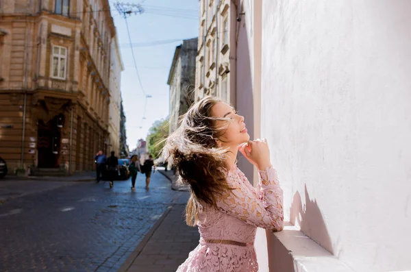 Lovely young woman with beautiful hair in wind posing at the str — Stock Photo, Image