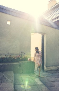 Duvarda poz veren şık elbiseli güzel esmer manken.