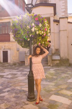 Genç ve güzel modeli dantel elbise ışınları yatakta çiçek yakınındaki poz