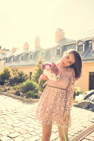 Gorgeous young model posing with flowers in rays of light. Vinta — Stock Photo, Image