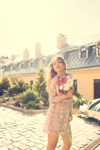 Elegantes brünettes Model, das mit Blumen in Lichtstrahlen posiert. Vin — Stockfoto