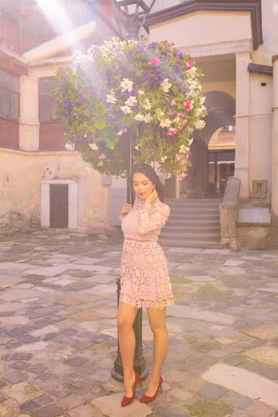 Işık ışınları yatakta çiçek yakınındaki poz güzel esmer kadın