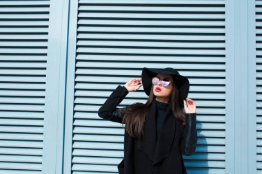 Şık palto ve şapka yakınındaki poz güzel esmer Bayan 