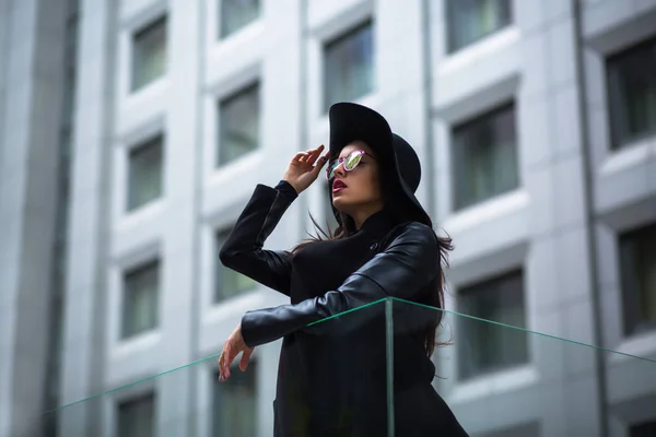 Mulher morena bonita em óculos e chapéu na rua. Cidade — Fotografia de Stock