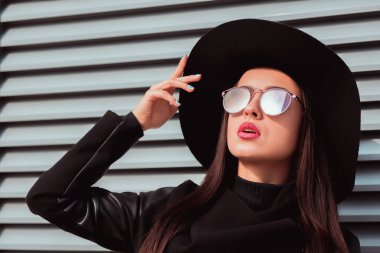 Portre portre genç lüks modeli şapka ve güneş gözlüğü takıyor.