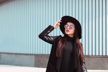 Sihir genç model trendy palto ve şapka takıyor. Sunglasse kadın