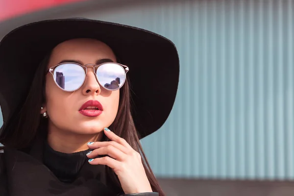 Уличный портрет привлекательной модели в модных солнцезащитных очках и хлеву — стоковое фото