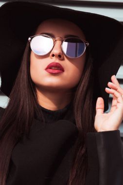 Şapka ve sunglass moda portre genç güzel modeli giyer