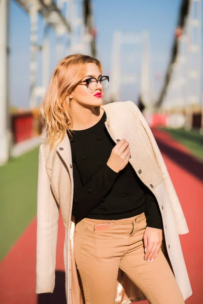 Fashion portrait of sexy young model wears beige coat and glasse — Stock Photo, Image