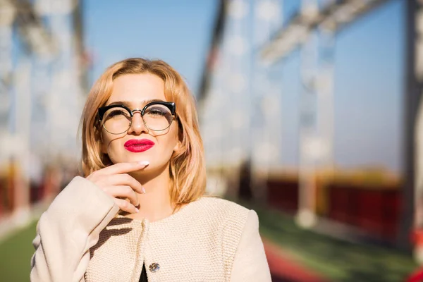 Elegant blonde woman wears beige coat and glasses. Empty space. — Stock Photo, Image