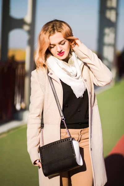 Street portrait of stylish blonde model wears beige coat , holdi — Stock Photo, Image