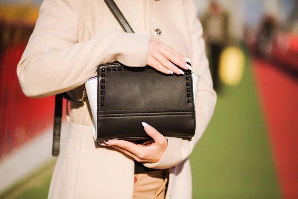 Fashionabla modell håller svart handväska och bär beige kappa — Stockfoto