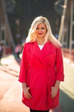 Güzel sarışın model parlak makyaj kırmızı paltolu poz ile