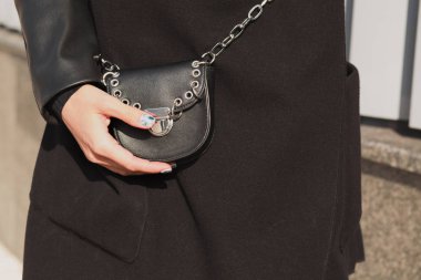 Trendy genç modeli küçük siyah pur tutarak siyah ceket giymiş.