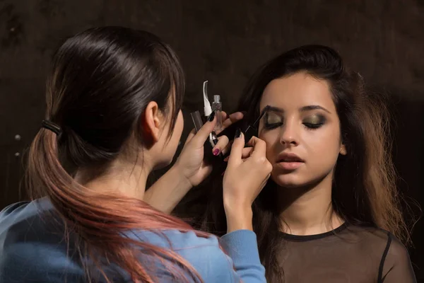 Maquillaje artista trabaja con modelo en el estudio — Foto de Stock