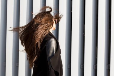 Rüzgarda, parlak gür saçlı esmer kadın, yürüyüş 