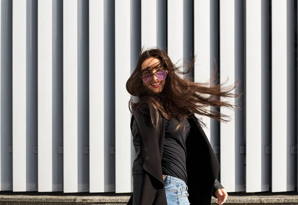 Gatan porträtt av glad ung modell med hår som blåser i vinden w — Stockfoto