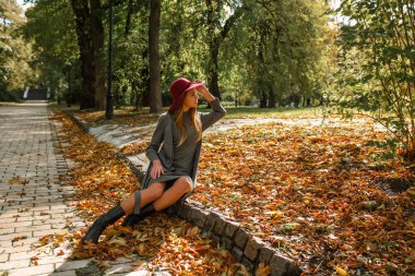 Gri renkli zarif sarışın kadın t oturan elbise ve kırmızı şapka örgü