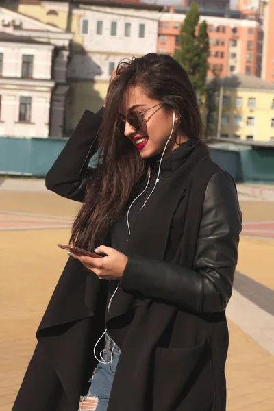 Pretty smiling brunette woman listen music on mobile telephone, — Stock Photo, Image