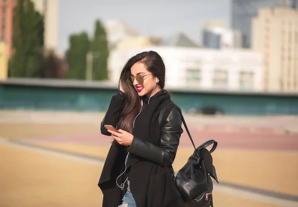 Usměvavá mladá žena turista v brýle poslouchat hudbu na Mobilní tele — Stock fotografie