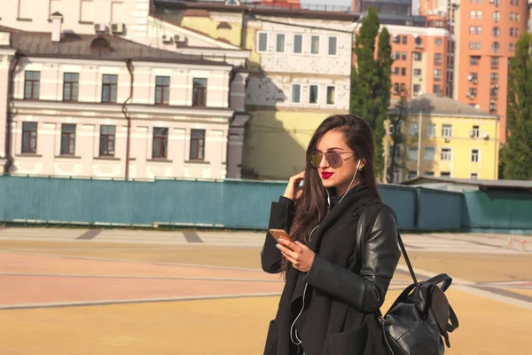 Glad brunett kvinna turist lyssna musik på mobil telefon, s — Stockfoto