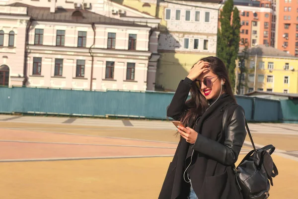 Souriant brunette femme touriste écouter de la musique sur téléphone mobile , — Photo