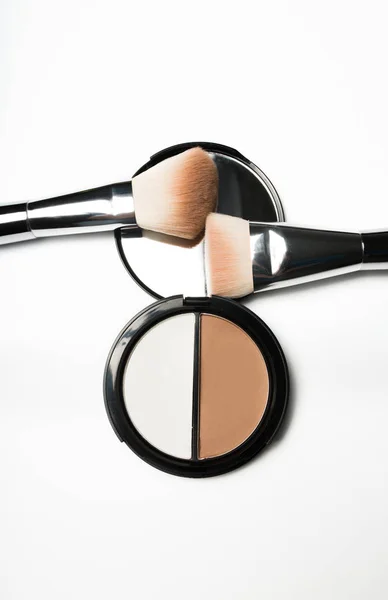 Kit of bronzer and highlighter with cosmetic brushes on a white — Stock Photo, Image