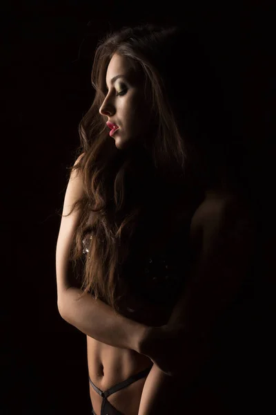 Sexy junge Frau mit üppigen Haaren in schwarzen Dessous posiert in der — Stockfoto