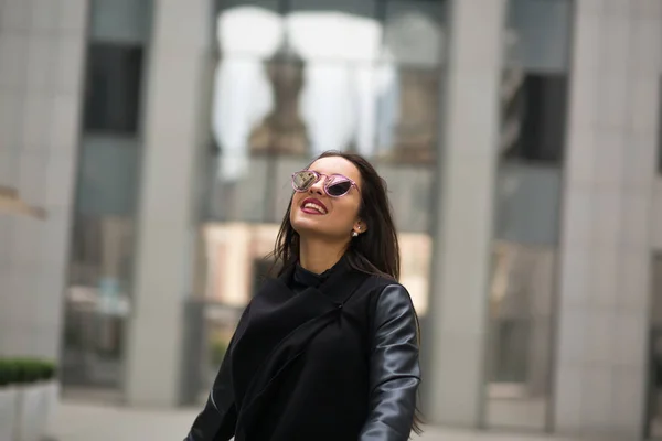 Élégant modèle souriant habillé avec des cheveux soufflant dans la promenade du vent — Photo