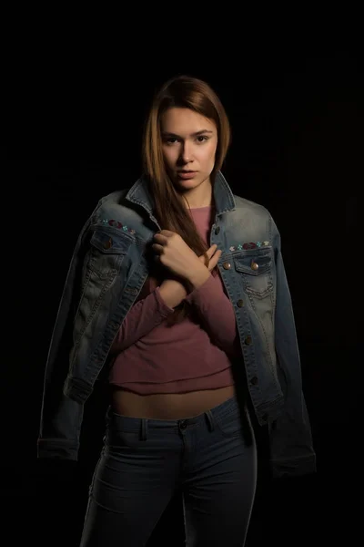 Model test for pretty young woman in jeans jacket posing on a bl — Stock Photo, Image
