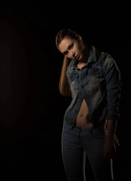 Erstaunliche junge Frau im trendigen Outfit posiert vor schwarzem Hintergrund — Stockfoto