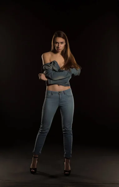 Elegante jovem mulher na jaqueta jeans na moda posando em preto backg — Fotografia de Stock