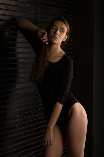 Módní mladá žena v černém prádle pózuje se stínem na — Stock fotografie