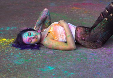 Muhteşem kadın yatan renkli Holi tozla kaplı bir