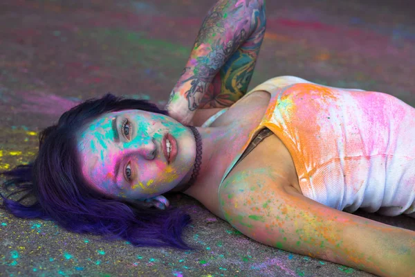 Чуттєва жінка, покрита барвистим порошком Холі, лежить на — стокове фото