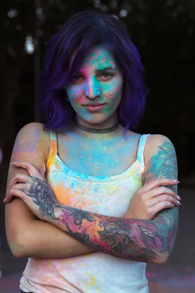 Wonderful woman with purple hair and tattoo on her arm covered w