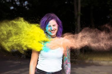 Kuru renk toz bayram şenlik üzerinde oynamaktan mutlu dövmeli kadın