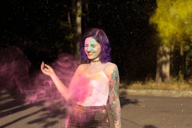 Renkli Holi tozu ile oynayan neşeli esmer kadın
