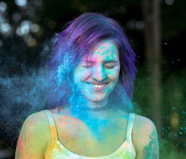 Gülümseyen kadın mor saçlı mavi Holi toz kaplı 