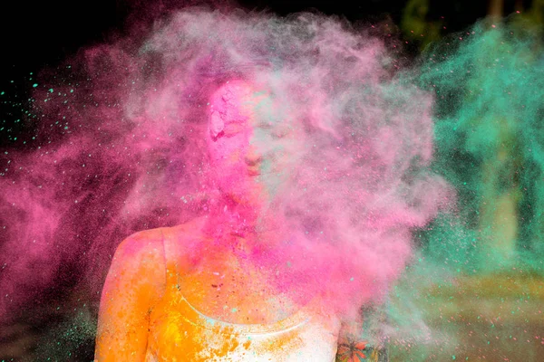 Mujer joven posando con explosivo rosa y verde Holi polvo ar — Foto de Stock