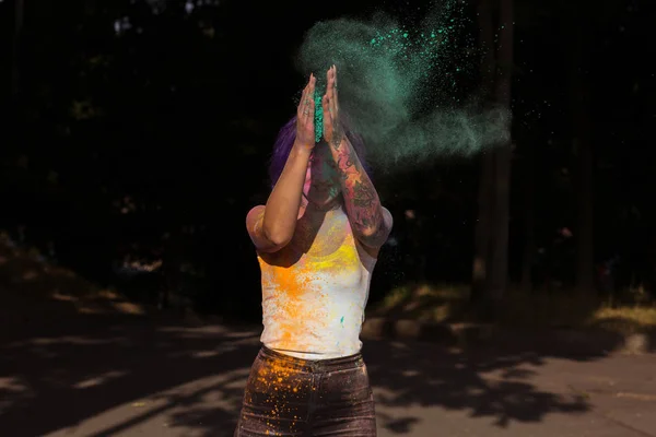 Ένδοξη γυναίκα με μωβ μαλλιά πετώντας μέχρι πολύχρωμα σκόνη Holi — Φωτογραφία Αρχείου