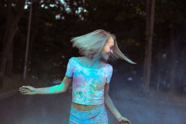 Etkileyici genç kadın saç pos çırpınan ile beyaz t shirt