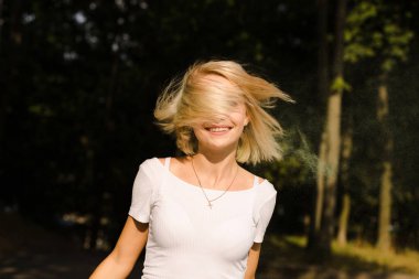 Hareket poz içinde saçlı beyaz t gömlek şık sarışın kadın