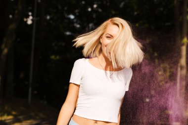 Rüzgar posin içinde saçlı beyaz t gömlek duygusal sarışın kadın