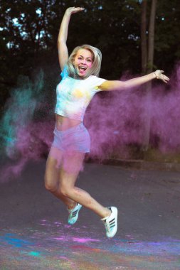 H patlayan Holi Tozu ile atlama neşeli genç kadın