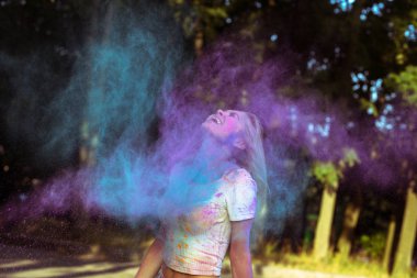 Holi p ile oynarken çırpınan saçlı ifade sarışın kadın