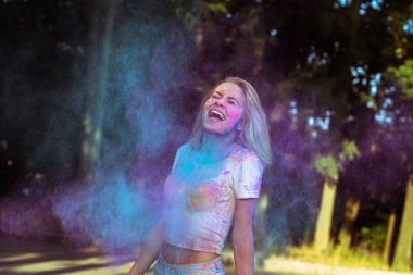 Holi pow ile oynarken çırpınan saçlı duygusal genç kadın