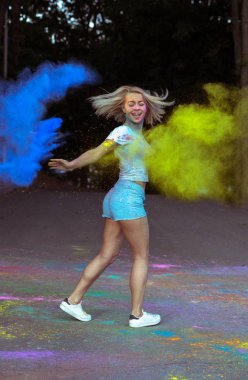 Holi fe kutluyor patlayan kuru boya ile gülümseyen genç kadın