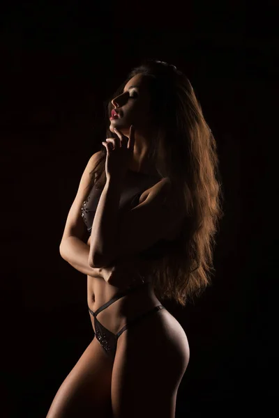 Schöne gebräunte Frau mit perfektem Körper und langen Haaren posiert in Se — Stockfoto
